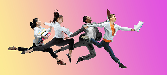 Image showing Happy office workers jumping and dancing in casual clothes or suit on gradient neon fluid background. Flyer with copyspace