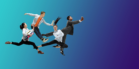 Image showing Happy office workers jumping and dancing in casual clothes or suit on gradient neon fluid background. Flyer with copyspace