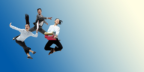 Image showing Happy office workers jumping and dancing in casual clothes or suit on gradient neon fluid background. Flyer with copyspace