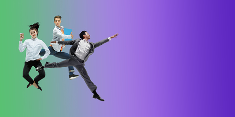 Image showing Happy office workers jumping and dancing in casual clothes or suit on gradient neon fluid background. Flyer with copyspace