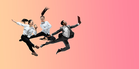 Image showing Happy office workers jumping and dancing in casual clothes or suit on gradient neon fluid background. Flyer with copyspace