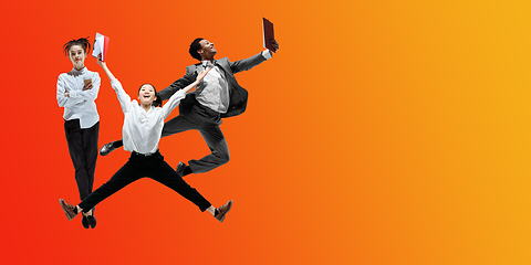 Image showing Happy office workers jumping and dancing in casual clothes or suit on gradient neon fluid background. Flyer with copyspace