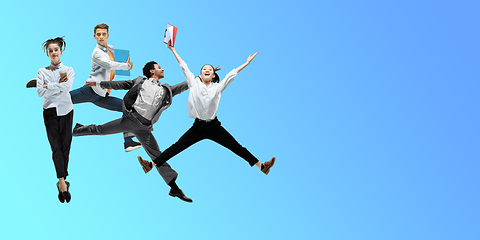 Image showing Happy office workers jumping and dancing in casual clothes or suit on gradient neon fluid background. Flyer with copyspace