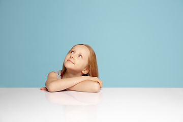 Image showing Happy redhair girl isolated on blue studio background. Looks happy, cheerful, sincere. Copyspace. Childhood, education, emotions concept