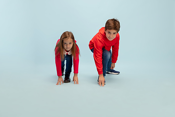 Image showing Happy children isolated on blue studio background. Look happy, cheerful, sincere. Copyspace. Childhood, education, emotions concept