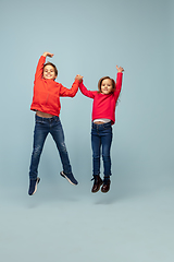 Image showing Happy children isolated on blue studio background. Look happy, cheerful, sincere. Copyspace. Childhood, education, emotions concept