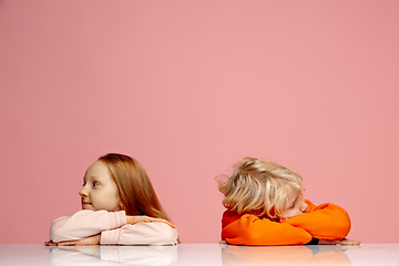 Image showing Happy children isolated on coral pink studio background. Look happy, cheerful, sincere. Copyspace. Childhood, education, emotions concept