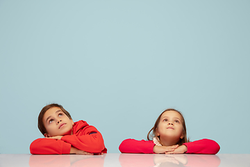 Image showing Happy children isolated on blue studio background. Look happy, cheerful, sincere. Copyspace. Childhood, education, emotions concept