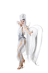 Image showing Beautiful young woman in carnival, stylish masquerade costume with feathers dancing on white studio background. Concept of holidays celebration, festive time, fashion