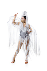 Image showing Beautiful young woman in carnival, stylish masquerade costume with feathers dancing on white studio background. Concept of holidays celebration, festive time, fashion