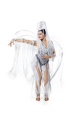 Image showing Beautiful young woman in carnival, stylish masquerade costume with feathers dancing on white studio background. Concept of holidays celebration, festive time, fashion