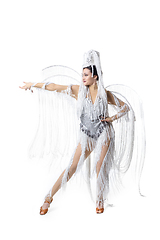 Image showing Beautiful young woman in carnival, stylish masquerade costume with feathers dancing on white studio background. Concept of holidays celebration, festive time, fashion