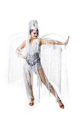 Image showing Beautiful young woman in carnival, stylish masquerade costume with feathers dancing on white studio background. Concept of holidays celebration, festive time, fashion