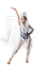 Image showing Beautiful young woman in carnival, stylish masquerade costume with feathers dancing on white studio background. Concept of holidays celebration, festive time, fashion