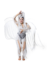 Image showing Beautiful young woman in carnival, stylish masquerade costume with feathers dancing on white studio background. Concept of holidays celebration, festive time, fashion