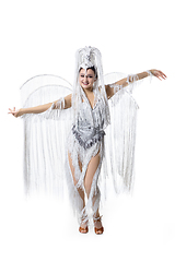 Image showing Beautiful young woman in carnival, stylish masquerade costume with feathers dancing on white studio background. Concept of holidays celebration, festive time, fashion