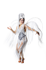 Image showing Beautiful young woman in carnival, stylish masquerade costume with feathers dancing on white studio background. Concept of holidays celebration, festive time, fashion