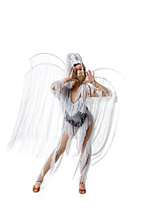 Image showing Beautiful young woman in carnival, stylish masquerade costume with feathers dancing on white studio background. Concept of holidays celebration, festive time, fashion