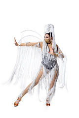 Image showing Beautiful young woman in carnival, stylish masquerade costume with feathers dancing on white studio background. Concept of holidays celebration, festive time, fashion