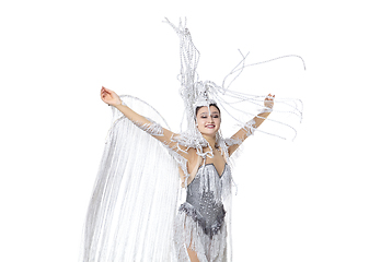 Image showing Beautiful young woman in carnival, stylish masquerade costume with feathers dancing on white studio background. Concept of holidays celebration, festive time, fashion