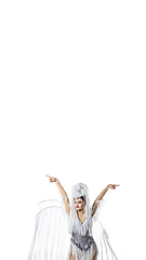 Image showing Beautiful young woman in carnival, stylish masquerade costume with feathers dancing on white studio background. Concept of holidays celebration, festive time, fashion