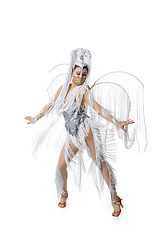 Image showing Beautiful young woman in carnival, stylish masquerade costume with feathers dancing on white studio background. Concept of holidays celebration, festive time, fashion