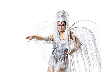 Image showing Beautiful young woman in carnival, stylish masquerade costume with feathers dancing on white studio background. Concept of holidays celebration, festive time, fashion