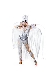 Image showing Beautiful young woman in carnival, stylish masquerade costume with feathers dancing on white studio background. Concept of holidays celebration, festive time, fashion