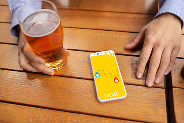 Image showing Close up hands holding smartphone with online taxi service on the screen. Staying safe during lockdown. Modern tech and healthcare