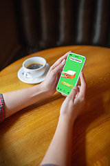 Image showing Close up hands holding smartphone with food delivery service on the screen. Staying safe during lockdown. Modern tech and healthcare