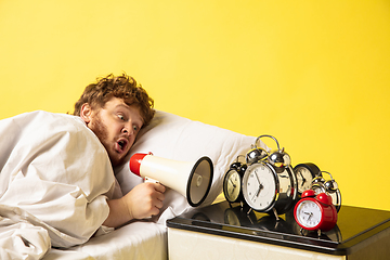 Image showing Man wakes up and he\'s mad at clock ringing, switches it off by breaking down with megaphone