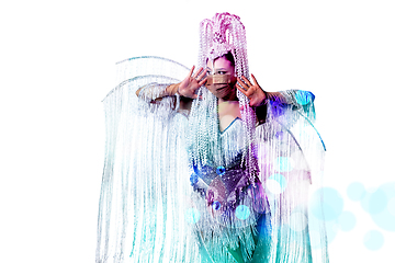 Image showing Beautiful young woman in carnival, stylish masquerade costume with feathers dancing on white studio background with shining bokeh