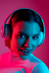 Image showing Caucasian woman\'s portrait isolated on pink studio background in multicolored neon light