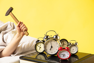 Image showing Man wakes up and he\'s mad at clock ringing, switches it off with the hammer