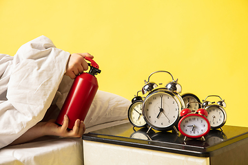 Image showing Man wakes up and he\'s mad at clock ringing, switches it off with the extinguisher