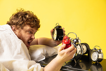 Image showing Man wakes up and he\'s mad at clock ringing, switches it off by breaking down