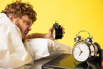 Image showing Man wakes up and he\'s mad at clock ringing, switches it off screaming