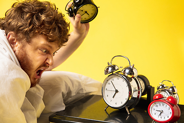 Image showing Man wakes up and he\'s mad at clock ringing, switches it off by breaking down