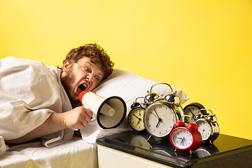 Image showing Man wakes up and he\'s mad at clock ringing, switches it off by breaking down with megaphone