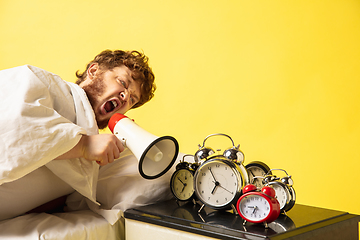 Image showing Man wakes up and he\'s mad at clock ringing, switches it off by breaking down with megaphone