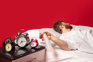 Image showing Man wakes up and he\'s mad at clock ringing, switches it off with water spraying