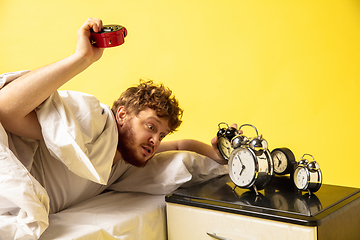 Image showing Man wakes up and he\'s mad at clock ringing, switches it off by breaking down