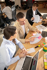 Image showing Young caucasian colleagues working together in a office using modern devices and gadgets