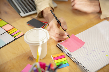 Image showing Hands of colleagues working together in a office using modern devices and gadgets during creative meeting. Close up.