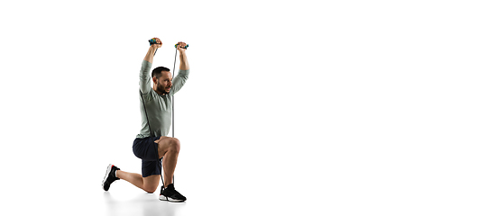 Image showing Young caucasian male model in action, motion isolated on white background. Concept of sport, movement, energy and dynamic, healthy lifestyle. Training, practicing.