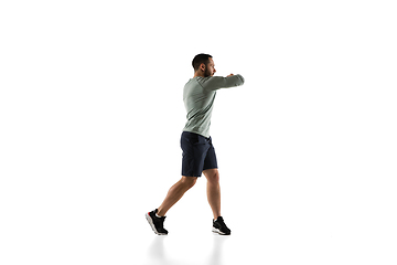 Image showing Young caucasian male model in action, motion isolated on white background. Concept of sport, movement, energy and dynamic, healthy lifestyle. Training, practicing.