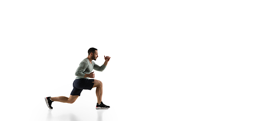 Image showing Young caucasian male model in action, motion isolated on white background. Concept of sport, movement, energy and dynamic, healthy lifestyle. Training, practicing.