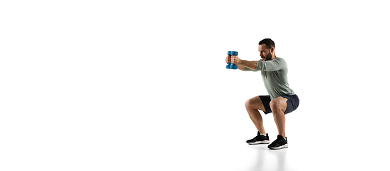 Image showing Young caucasian male model in action, motion isolated on white background. Concept of sport, movement, energy and dynamic, healthy lifestyle. Training, practicing.