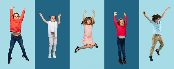 Image showing Group of elementary school kids or pupils jumping in colorful casual clothes on blue studio background. Creative collage.