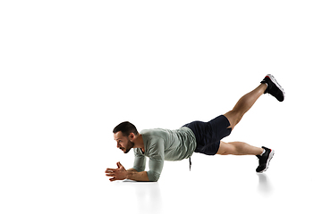 Image showing Young caucasian male model in action, motion isolated on white background. Concept of sport, movement, energy and dynamic, healthy lifestyle. Training, practicing.